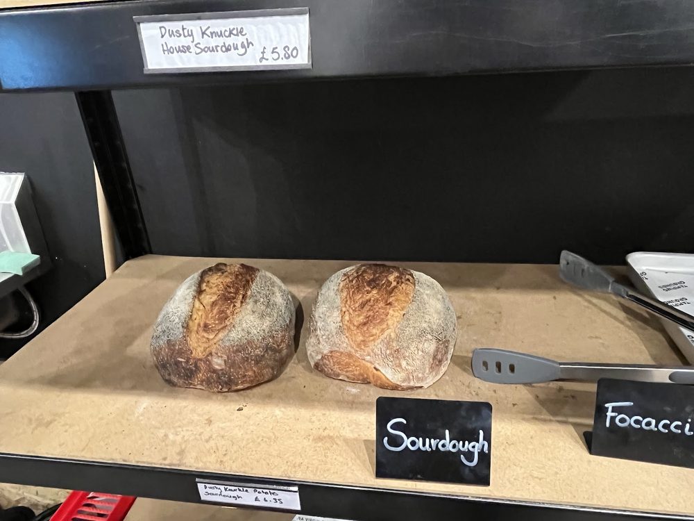 Round sourdough loaves on the wooden bakery shelf inside the shop