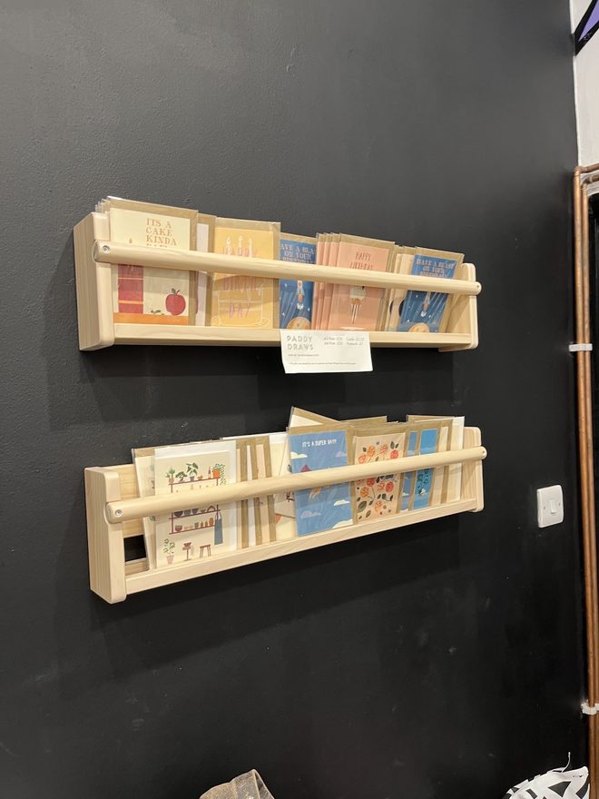 Book and zine ledges on a black wall