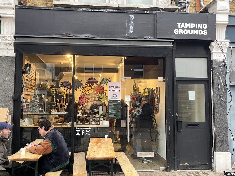 The black shopfront of Tamping Grounds on Francis Road, with benches outside and a window counter inside