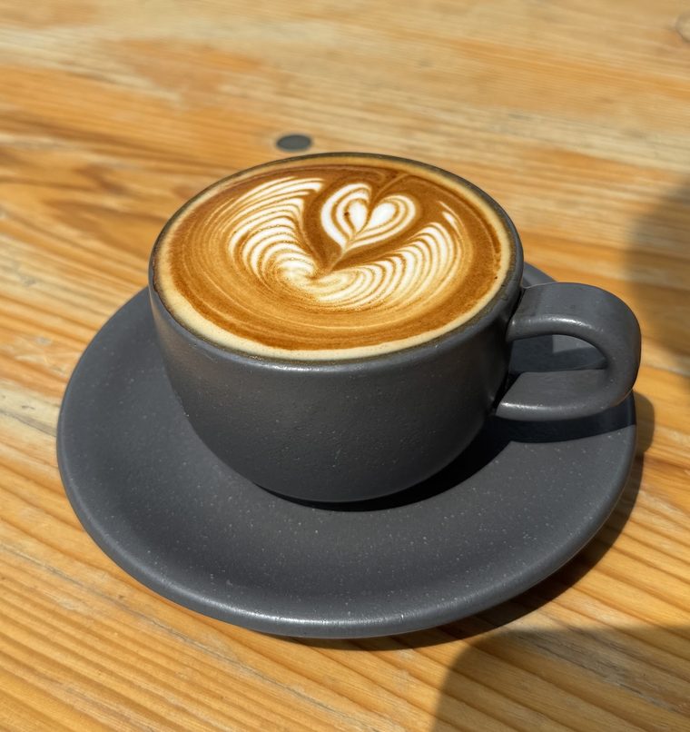 Flat white in a dark grey cup and saucer