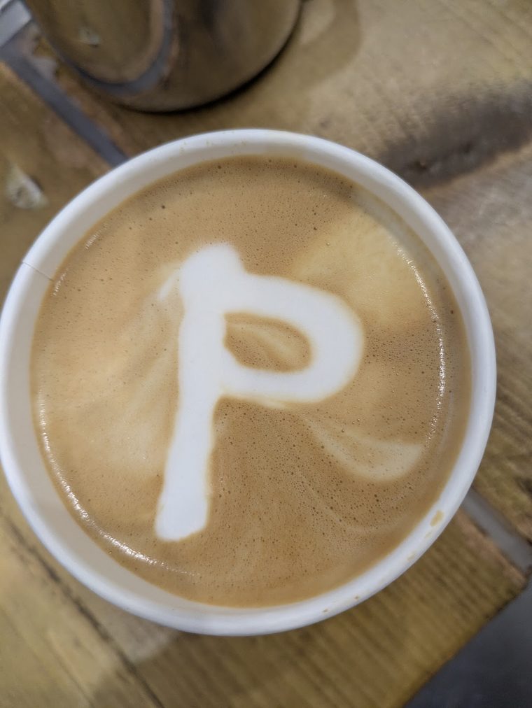 Top-down white cup of coffee with a design in the milk foam